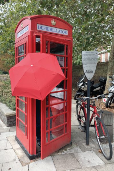 Lady Thérèse in a red phone booth come defibrillator in London.